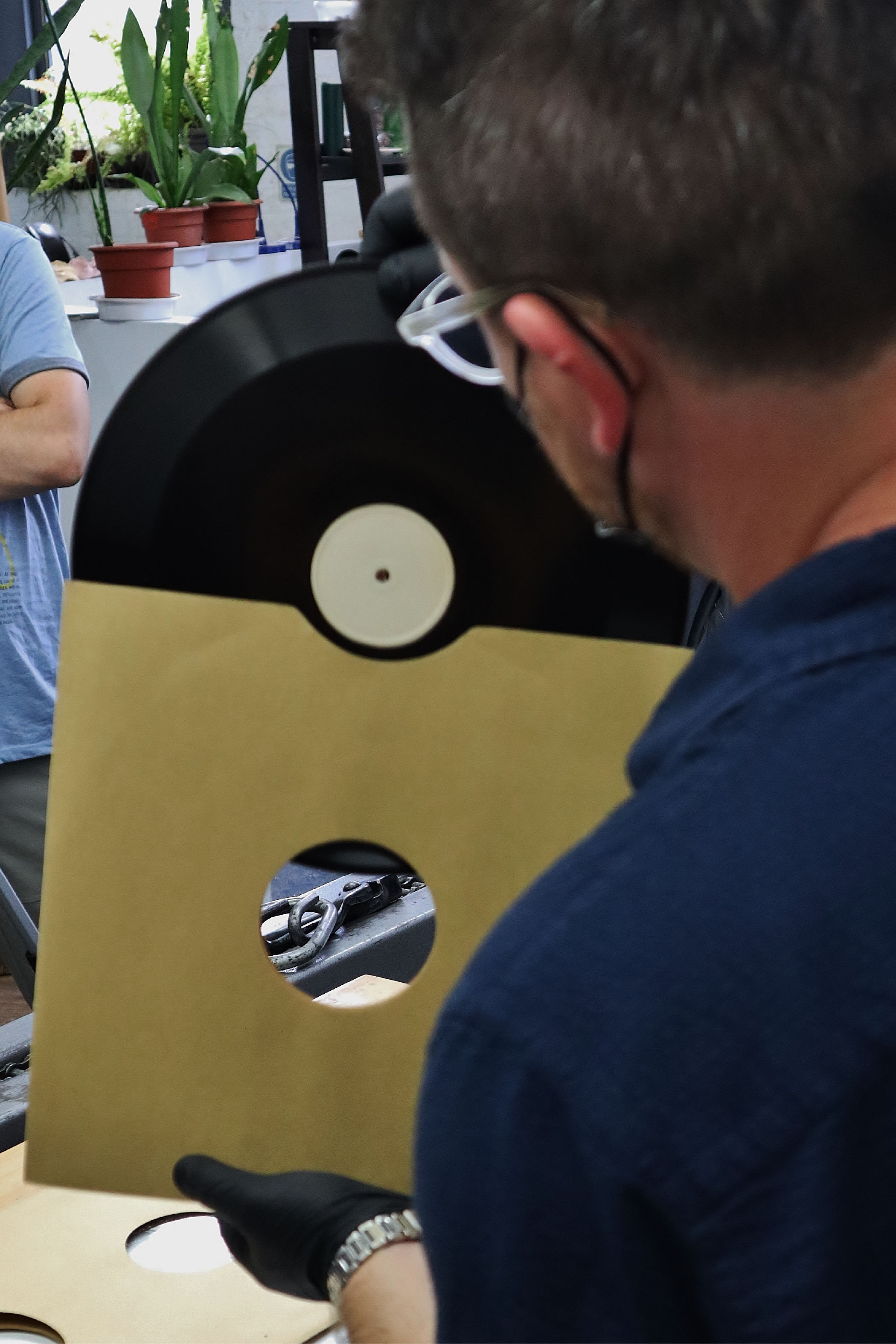 An archivist unveils a record, removing the disk from its sleeve.